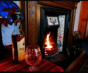una bottiglia di vino e un bicchiere accanto al caminetto di Relaxing Break in the Countryside a Foyle Bridge