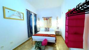Playa del Burreroにある"Burrero Bay Høme" Geniu's Best Selection - Airport Homely Staysのピンクの壁のベッドルーム1室(白いベッド1台付)
