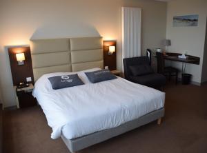 a hotel room with a bed and a chair at Hotel Les Galets Bleus in Cayeux-sur-Mer