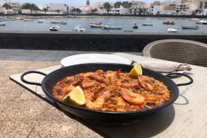Una sartén con comida encima de una mesa en The Penthouse Ascona in El Charco, en Arrecife