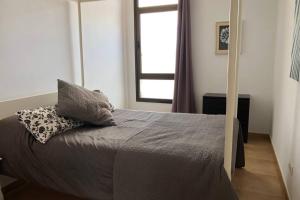 Un dormitorio con una cama con dos almohadas y una ventana. en The Penthouse Ascona in El Charco, en Arrecife