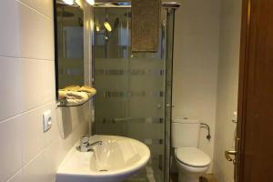 Un baño con lavabo, inodoro y ducha. en The Penthouse Ascona in El Charco, en Arrecife