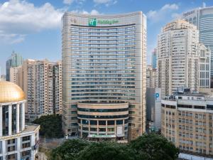 a tall building with a sign on it in a city at Holiday Inn Shanghai Nanjing Road by IHG in Shanghai
