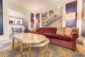 a living room with a red couch and a table at Inn at the Park in San Diego