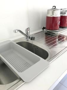 a sink in a kitchen with a red appliance at Studio at Boucan Canot 900 m away from the beach with enclosed garden and wifi in Boucan Canot