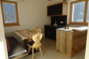 uma cozinha com uma mesa de madeira e uma cadeira de madeira em Schmalzlhof em Siusi