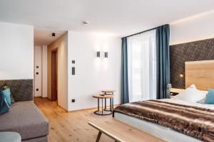 
a bedroom with a large bed and a large window at Turmchalet in Braies
