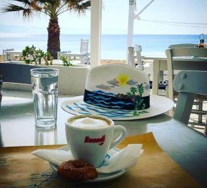 a cup of coffee and a donut on a table at Fisilanis Beachfront Hotel in Logaras