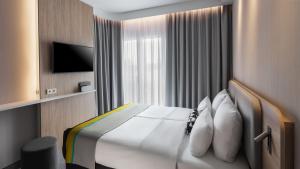 a hotel room with a bed and a television at Holiday Inn Express Düsseldorf - Hauptbahnhof by IHG in Düsseldorf +54 photos