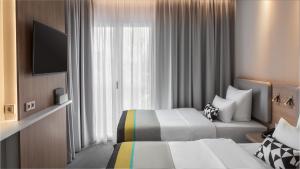 ein Hotelzimmer mit 2 Betten und einem Fenster in der Unterkunft Holiday Inn Express Düsseldorf - Hauptbahnhof, an IHG Hotel in Düsseldorf