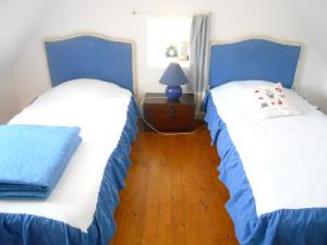 2 letti in una camera con blu e bianco di Maison de 2 chambres avec jardin clos et wifi a Cleden Cap Sizun a 4 km de la plage a Cléden-Cap-Sizun