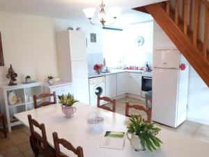 a kitchen with a white table and a white refrigerator at Chestnut in Langoëlan