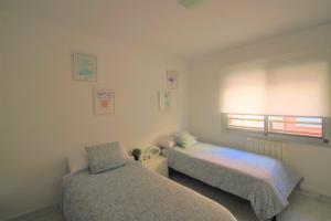 a bedroom with two beds and a window at Apartamento CasaTuris con vistas a la playa del Postiguet A103 in Alicante