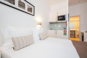 a hotel room with a white bed and white walls at Mystay Porto Batalha in Porto