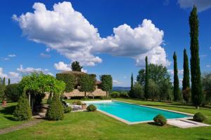 Villa dʼArcenoにあるCamparone Light, ArcenoRentalsClub Magnificent Chianti Villa Exclusive Pool Conciergeの木々と建物のある庭園のプール