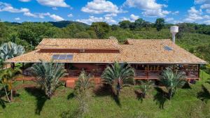 une vue aérienne sur une maison avec un toit dans l'établissement Sítio Pandora no interior de Minas, Pedro Leopoldo por Carpediem, à Pedro Leopoldo