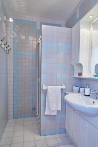 uma casa de banho em azulejos azuis com um lavatório e um espelho em Room 143 Monolocale vicino al centro em Camerano