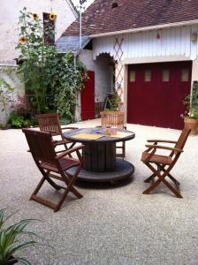 a patio with a table and two chairs and a garage at Chambre-studio Le 42 in Nogent-le-Rotrou