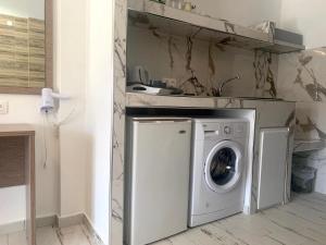 una lavatrice in cucina con lavandino di Polykratis Rooms a Città di Skiathos