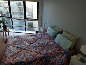 1 dormitorio con 1 cama con edredón en Duplex Cabildo en Buenos Aires