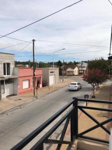 an empty street with a white car on the road at Los 7 Deseos in Tandil
