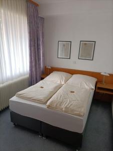 a bed in a bedroom with two lamps and a window at Hotel-Restaurant Babylon in Dierdorf