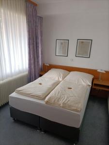 ein Bett in einem Schlafzimmer mit zwei Lampen und einem Fenster in der Unterkunft Hotel-Restaurant Babylon in Dierdorf