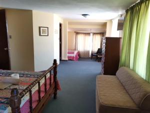 a hotel room with a bed and a couch and a bedroom at A&A apartamento in Cochabamba
