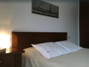 ポリェンサにあるApartamento Llenaireのベッドルーム1室(木製ヘッドボード付きのベッド1台付)