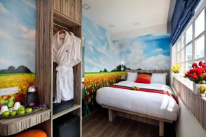 
a room with a bed and a painting on the wall at Hotel Clover The Arts (SG Clean) in Singapore
