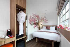 
a bedroom with a bed and a dresser at Hotel Clover The Arts (SG Clean) in Singapore
