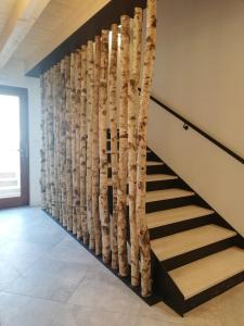 a staircase with a wall made out of tree branches at Crocevia - Locanda carsica contemporanea in Trieste
