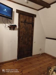 a room with a wooden door and a tv at Готельний комплекс Трапезна in Subbotov