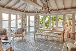 a living room with a table and chairs and windows at Morro Alacati in Alacati