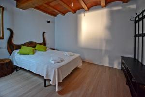a bedroom with a bed with green pillows on it at Casa del Tio Vicente in Calaceite
