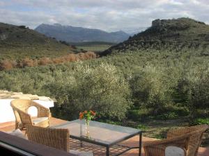 une table et des chaises sur un balcon avec vue sur les montagnes dans l'établissement Casa Rural La Cateta, à Mancha Real