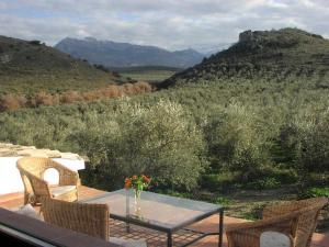 a table and chairs on a balcony with a view of mountains at Casa Rural La Cateta in Mancha Real