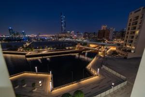 Blick auf einen Fluss in der Nacht mit einer Brücke in der Unterkunft Suha Creek Hotel Apartment, Waterfront Jaddaf, Dubai in Dubai