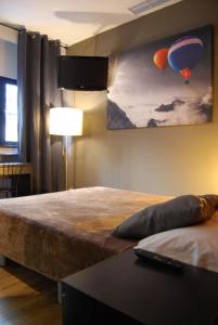 1 dormitorio con 1 cama grande y una pintura de globos en Hostal Don Pedro, en Madrid