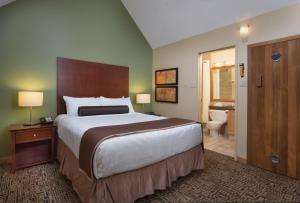 a bedroom with a large bed and a bathroom at Mountainside Lodge in Whistler