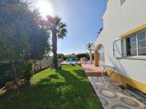ein Hof mit einer Palme neben einem Haus in der Unterkunft Villa Duartes in Altura