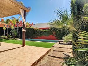 d'un jardin avec une terrasse clôturée et des palmiers. dans l'établissement Las Villas de Mar de Cristal- 3309, à Mar de Cristal