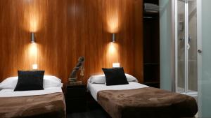 A bed or beds in a room at Hostal Don Pedro