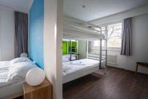 Un dormitorio con una litera y una ventana grande. en Nyon Hostel, en Nyon
