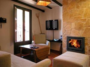 a living room with a fireplace and a tv at Casa Rural FranciaQuilamas in Santibáñez de la Sierra
