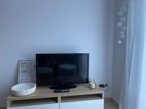 TV de pantalla plana en la parte superior de un armario en Funcional apartamento en Sitges