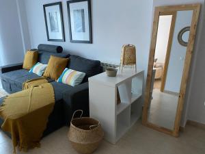 sala de estar con sofá azul y espejo en Funcional apartamento en Sitges