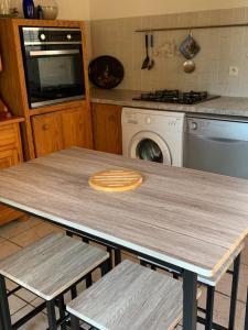 una cucina con tavolo in legno e 2 sedie di Gîte à Poggiale de Figari a Figari