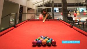 a woman playing a game of pool on a pool table at Vila Galé Resort Cumbuco - All inclusive in Cumbuco