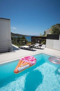 a swimming pool with an inflatable raft in the water at Entire private top floor with own pool and entrance in Primošten